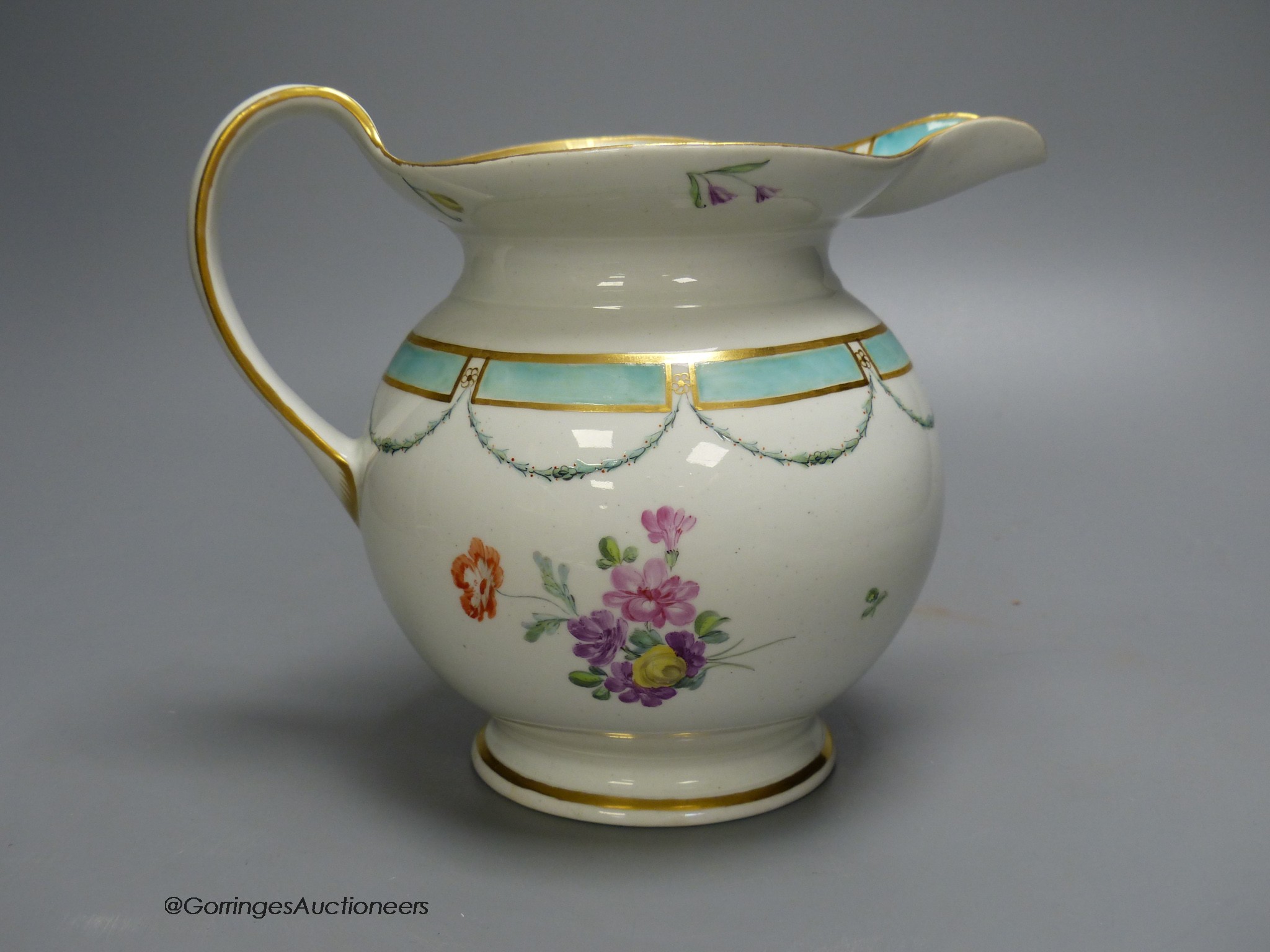 A Chelsea Derby jug of most unusual shape painted with flowers and a turquoise border, 18cm high